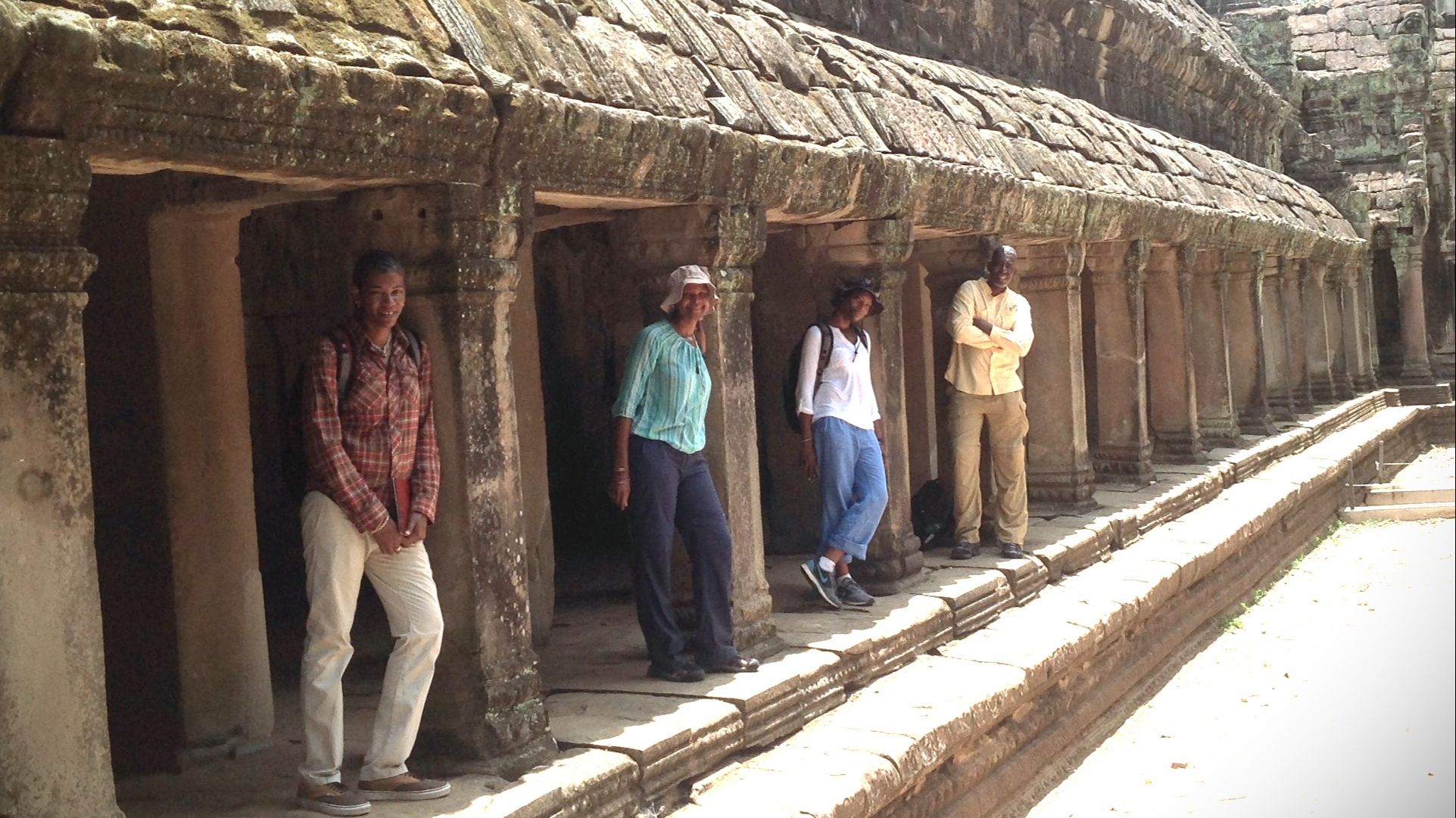 3 Black females and 1 Black male standing among the ruins at Angkor Wat in Siem Reip, Cambodia